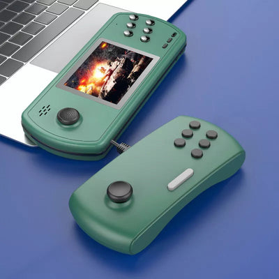 Green handheld retro gaming console with detachable controller and action game on screen next to laptop