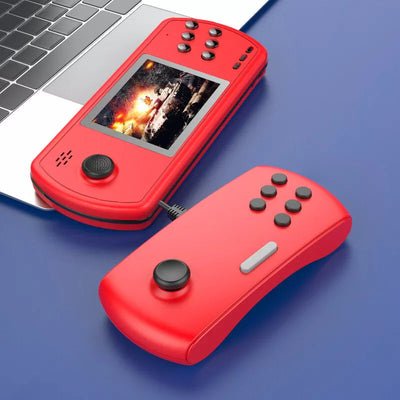 Red handheld retro gaming console with detachable controller showing a tank battle game by a laptop